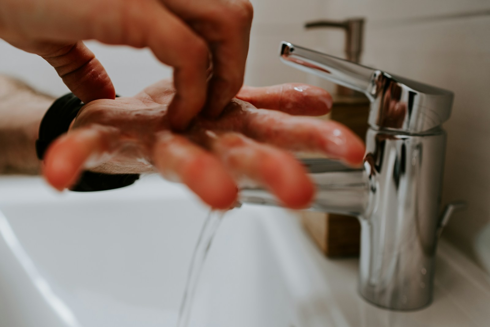 Hände beim Einseifen über einem Waschbecken